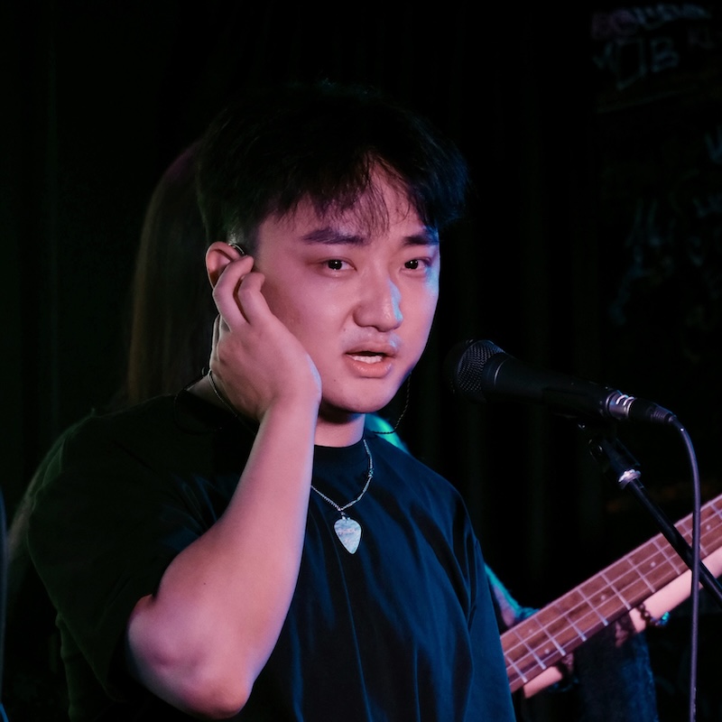 William 与乐队演出,在舞台上弹奏贝斯并演唱